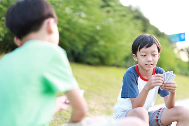 Boy playing cards Family playing cards child gambling chip gambling poker stock pictures, royalty-free photos & images