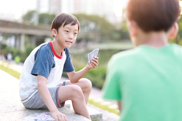 Boy playing cards Family playing cards child gambling chip gambling poker stock pictures, royalty-free photos & images