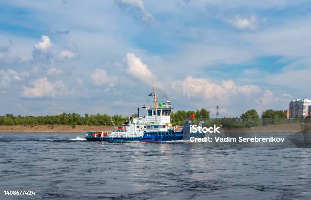 River Tug Boat Is Moving Along The Water Against Cityscape Stock Photo - Download Image Now