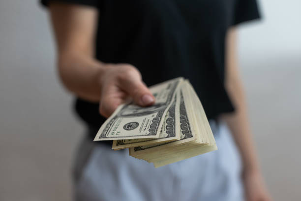 istock woman holding money over white wall background 1408677780