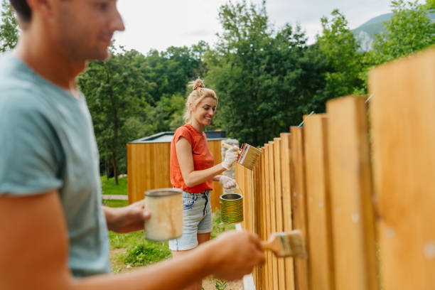 istock Young couple painting a picket fence 1408681521