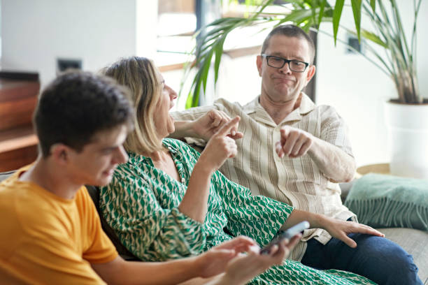 istock Playful family laughing, signing, and using smart phone 1408686782