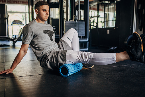 One man, fit young man warming up before training in gym alone.