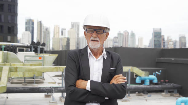 istock An old elderly engineer man or worker, people talking on webcam video call conference, working in industry factory. Chiller tower or cooling tower in building. System work machine pipe lines. 1408697276