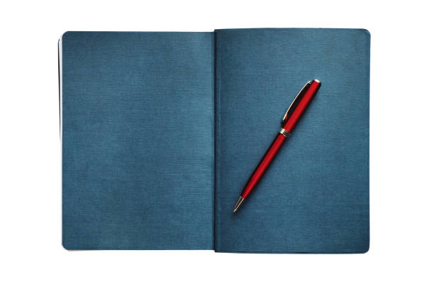 istock Open diary and metallic red ballpoint pen isolated on white background 1408699087