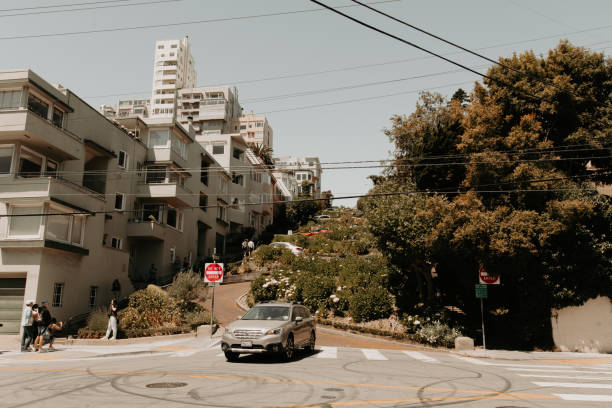 cars driving down the hairpin turns on famous lombard street in san francisco - lombard street city urban scene city life imagens e fotografias de stock