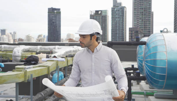 istock An engineer man or worker, people working in industry factory. Chiller tower on rooftop building. System work machine. Condenser Water Supply pipe lines. Ventilation compressor. Workshop site. 1408707408