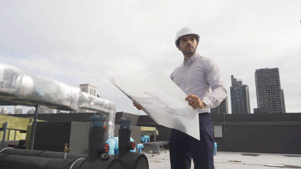 istock An engineer man or worker, people working in industry factory. Chiller tower on rooftop building. System work machine. Condenser Water Supply pipe lines. Ventilation compressor. Workshop site. 1408707427