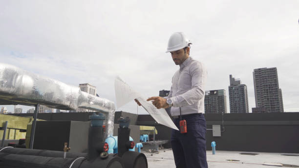 istock An engineer man or worker, people working in industry factory. Chiller tower on rooftop building. System work machine. Condenser Water Supply pipe lines. Ventilation compressor. Workshop site. 1408707442
