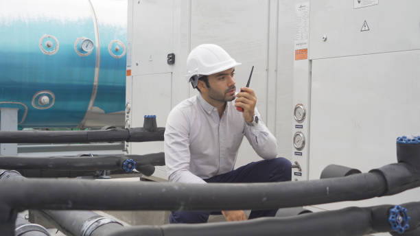 istock An engineer man or worker, people working in industry factory. Chiller tower on rooftop building. System work machine. Condenser Water Supply pipe lines. Ventilation compressor. Workshop site. 1408707508