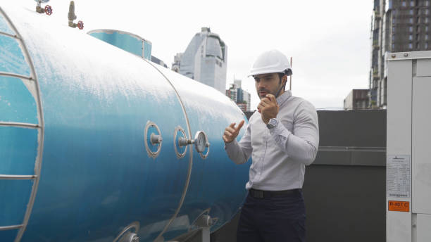 istock An engineer man or worker, people working in industry factory. Chiller tower on rooftop building. System work machine. Condenser Water Supply pipe lines. Ventilation compressor. Workshop site. 1408707516