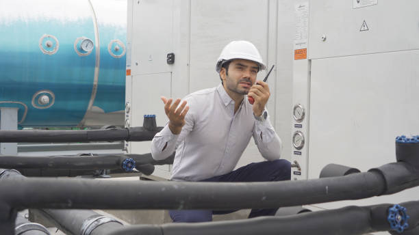 istock An engineer man or worker, people working in industry factory. Chiller tower on rooftop building. System work machine. Condenser Water Supply pipe lines. Ventilation compressor. Workshop site. 1408707523