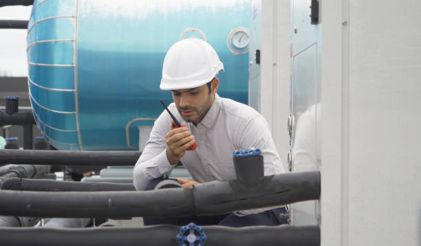 istock An engineer man or worker, people working in industry factory. Chiller tower on rooftop building. System work machine. Condenser Water Supply pipe lines. Ventilation compressor. Workshop site. 1408707550