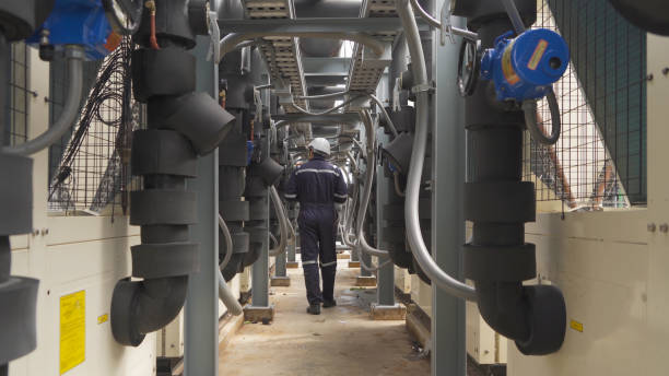 istock An engineer man or worker, people working in industry factory. Chiller tower on rooftop building. System work machine. Condenser Water Supply pipe lines. Ventilation compressor. Workshop site. 1408707570
