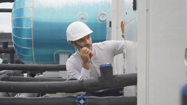 istock An engineer man or worker, people working in industry factory. Chiller tower on rooftop building. System work machine. Condenser Water Supply pipe lines. Ventilation compressor. Workshop site. 1408707591