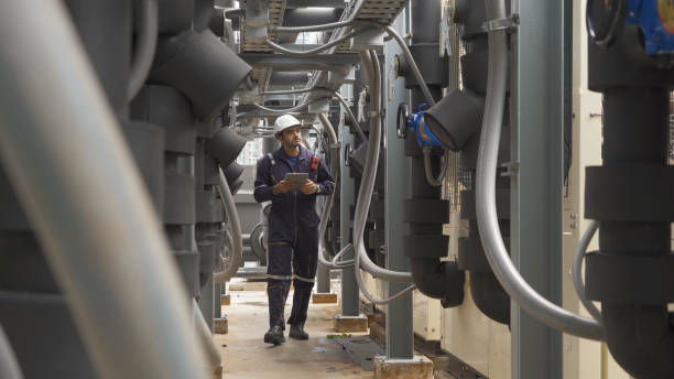 istock An engineer man or worker, people working in industry factory. Chiller tower on rooftop building. System work machine. Condenser Water Supply pipe lines. Ventilation compressor. Workshop site. 1408707617