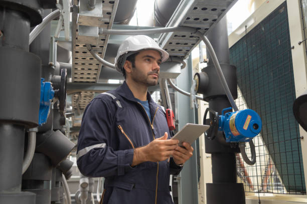 istock An engineer man or worker, people working in industry factory. Chiller tower on rooftop building. System work machine. Condenser Water Supply pipe lines. Ventilation compressor. Workshop site. 1408707795