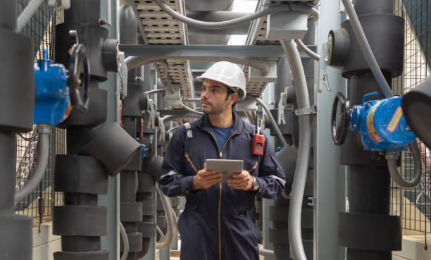 istock An engineer man or worker, people working in industry factory. Chiller tower on rooftop building. System work machine. Condenser Water Supply pipe lines. Ventilation compressor. Workshop site. 1408707838