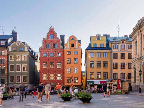 Stockholm, Sweden - June 26 2022: Stortorget, the big square, in Gamla Stan, old town, with traditional colorful old buildings on a summer day with tourists and locals walking and sitting at cafes