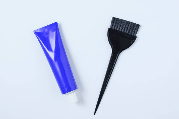 blue tube hair dye and hair dye brush. white background. - blue tint imagens e fotografias de stock