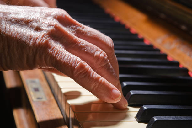 istock Elderly female hand playing the old piano. 1408711605