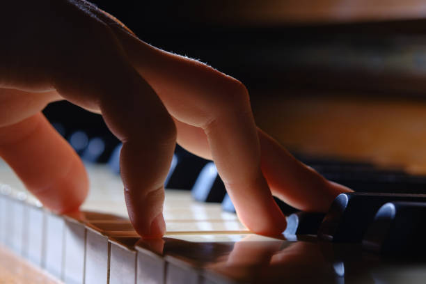 Hand of little girl playing the piano. Little girl playing the old piano. Close up of young girls hand. Selective focus. pianist stock pictures, royalty-free photos & images