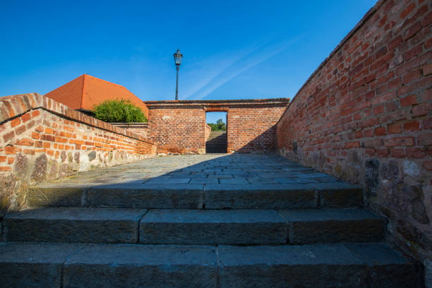 istock Stairs and path with interlocking paving. There is a brick wall on the side. The sky is blue without clouds. 1408712182