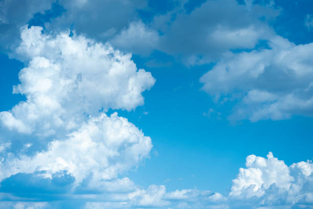 Summer morning with blue sky and puffy white cumulus clouds. The image is part of series that offers ample space for copy/text for presentations of summer, sky, cloudscape, hope, exploration, future, environment, travel, green energy, wind turbins, etc. The image was captured with a full frame (mirrorless) digital camera and a sharp short prime telephoto lens (f/1.8) at f/2.8, low ISO (100) and very short shutter speed, resulting in clean, large files of professional quality suitable for any type of publication. The image was captured in Atlanta, Georgia, USA in the early July.