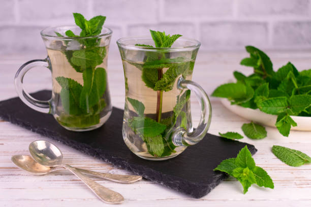 istock Mint tea. Soothing tea with fresh mint on a rustic white background. 1408721628