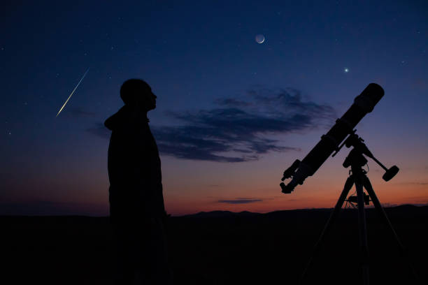 istock Man with astronomical telescope observing night sky, under the Mlky way stars. 1408722855
