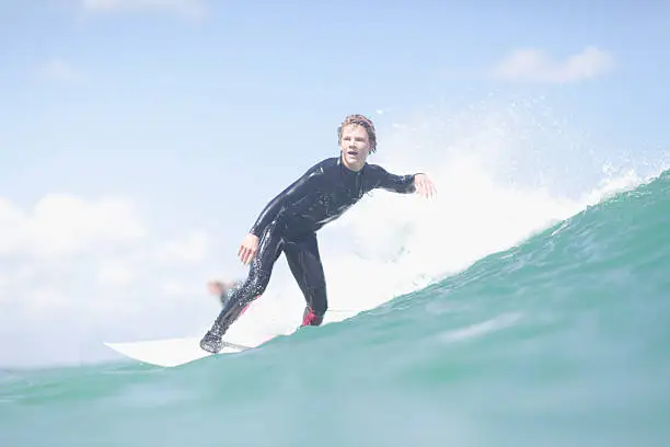 Photo of Teenage surfer riding a wave