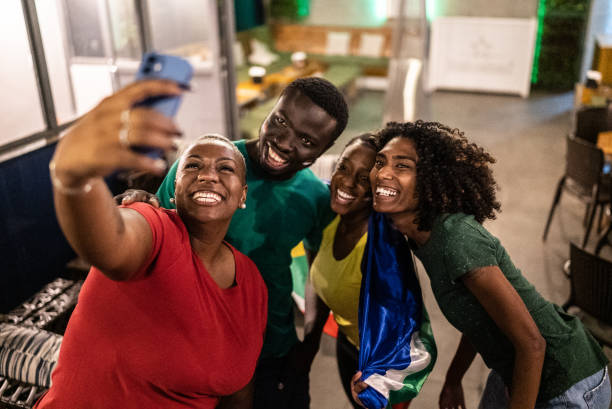 istock Sport fan friends taking a selfie using mobile phone in a bar 1408728806