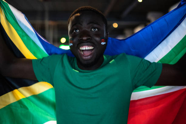 istock Young man celebrating holding South African flag 1408729943