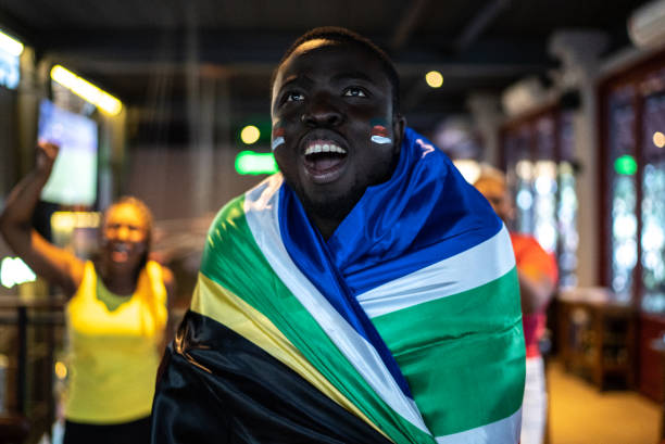istock Young man celebrating South African team scoring a goal in a bar 1408729949