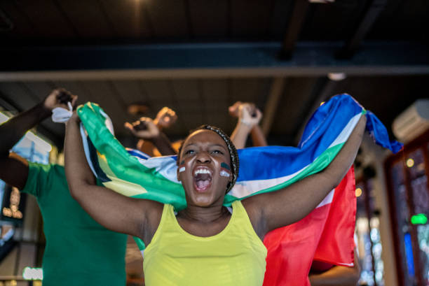 istock Young woman celebrating team scoring a goal in a bar 1408730121