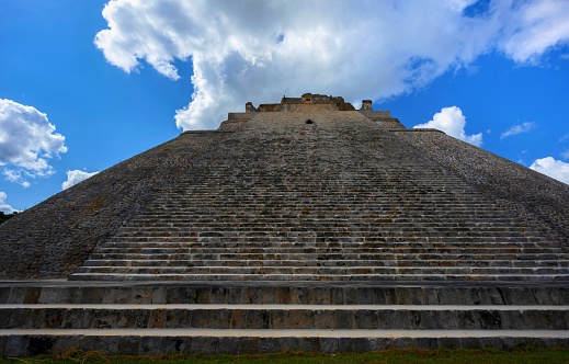 Uxmal, Mexico, December 5, 2016: Low angle view of the Pyramid of the Magician. Uxmal on the Yucatan Peninsula is considered one of the most important archaeological sites of Maya culture. It has been designated a UNESCO World Heritage Site.