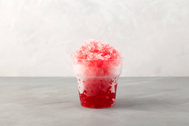 istock Sweet shaved ice or Spanish granizado in disposable plastic cup on grey background. Red Slushie - drink with natural juice. Refreshing summer drink 1408737621
