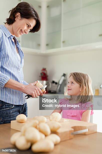Mother Helping Daughter Peel Potatoes Stock Photo - Download Image Now - Prepared Potato, Making, Mother