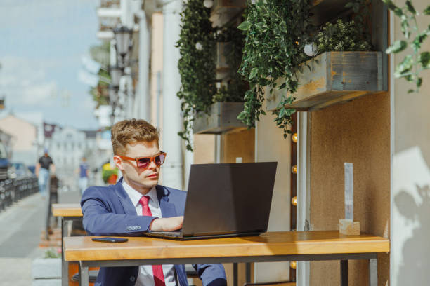 istock Young freelancer entrepreneur in suit works on laptop while sitting on terrace 1408748176