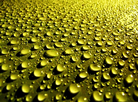 Many rain drops on a surface making an abstract design.