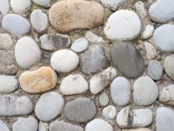 istock Wall tiles made of large smooth stones. Pebbles in cement. Creative wall decoration. 1408752454