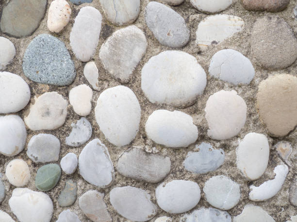 istock Wall tiles made of large smooth stones. Pebbles in cement. Creative wall decoration. 1408752455