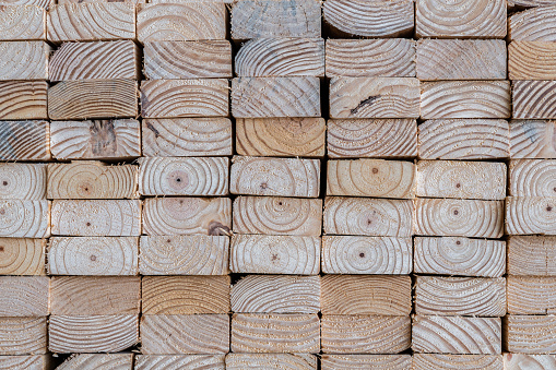 Photograph of the end profile of a stack of 2 x 4's in a lumber yard featuring the wood grain