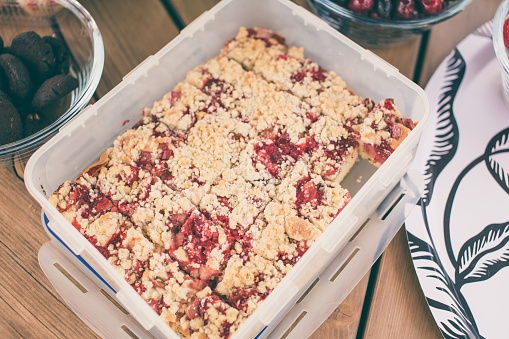 Plum cake in a plastic box viewed from above