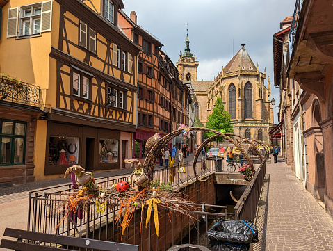 St Martin's Church in daytime viewed from along canal at Easter in Colmar France