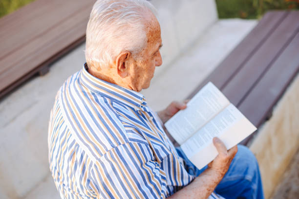 istock Happy senior man relaxing in nature with a book 1408763222