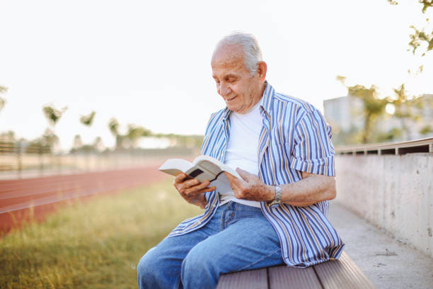 istock Happy senior man relaxing in nature with a book 1408763500