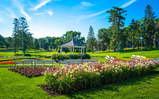 Vibrant sunrise garden landscape with a pavilion, benches, and flowers. Bright cheerful public park landscape at Tuthill Park in Sioux Falls, South Dakota.