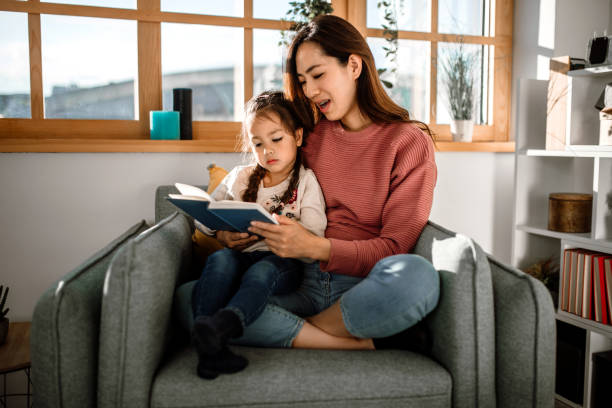 istock Mother and little daughter reading book together 1408770024