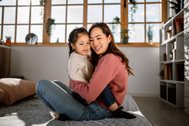 istock Mother and daughter embracing, lying in bed 1408770055